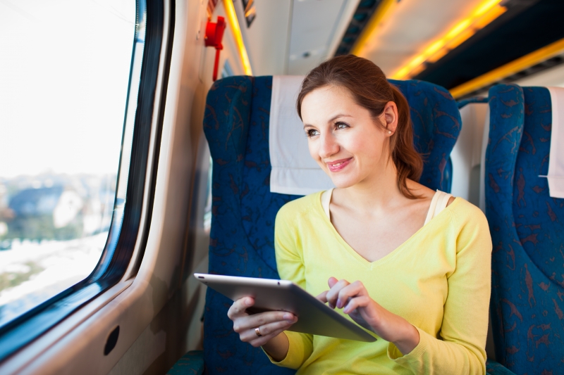 8698339-young-woman-using-her-tablet-computer-while-traveling-by-train